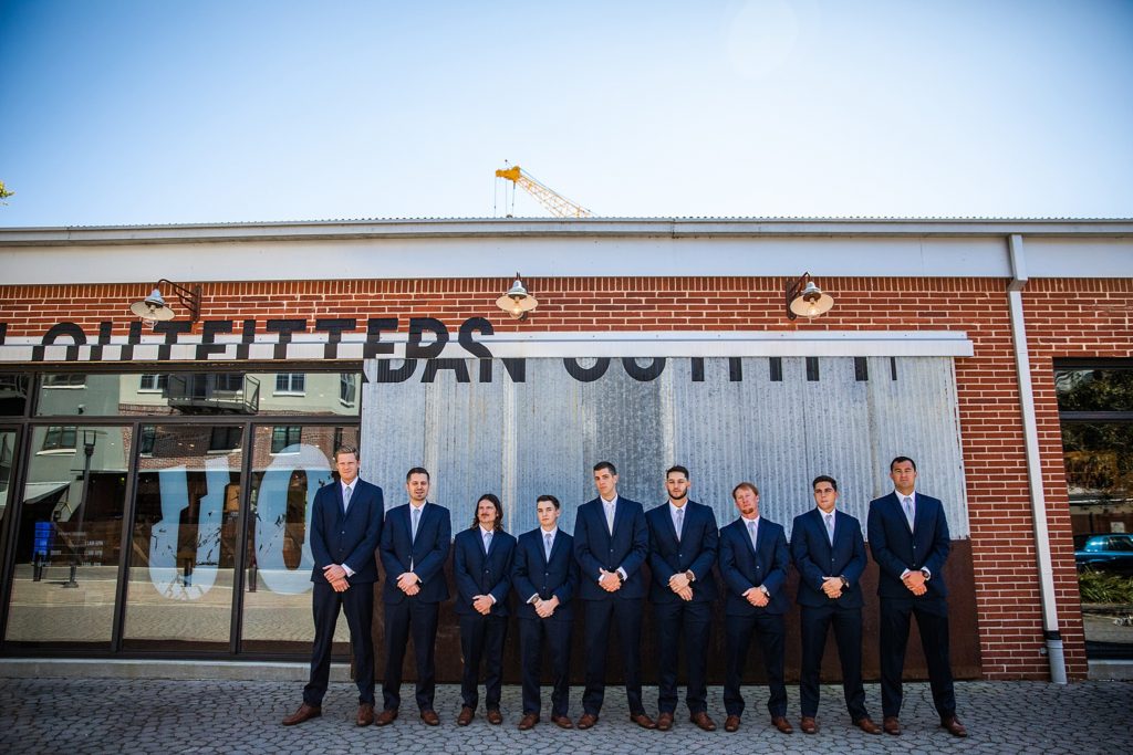 Groomsmen standing by Urban Outfitters in Collegetown in Tallahassee, Florida